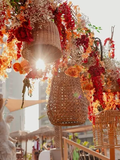 Woven baskets and vibrant flowers hanging overhead, creating a beautiful, sun-dappled effect.