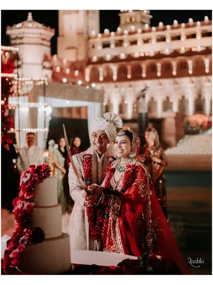 The cake cutting ceremony, a moment of celebration with the stunning palace facade as the backdrop.