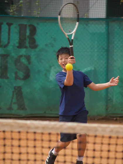 A young athlete from Singapore focusing on his forehand during our international camp. These collaborations provide invaluable exposure and cross-cultural learning.