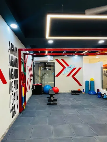 Another view of our gym floor, showing the open layout that allows for diverse training setups. You can see our monkey bars for upper body strength and various kettlebells and balance tools ready for use.