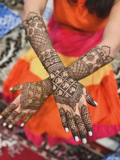 This design features a unique pattern of elephants within a grid on the back of the hands, showcasing a creative approach to traditional motifs.