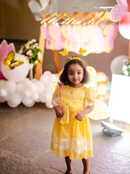 The birthday girl dressed as a beautiful butterfly, complete with a magic wand and antennae headband.
