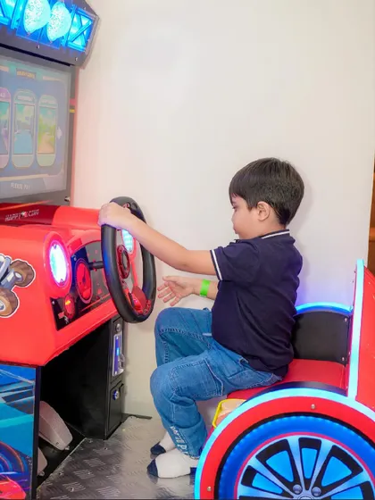 A young guest concentrates on the screen as he enjoys a racing game in our arcade section.
