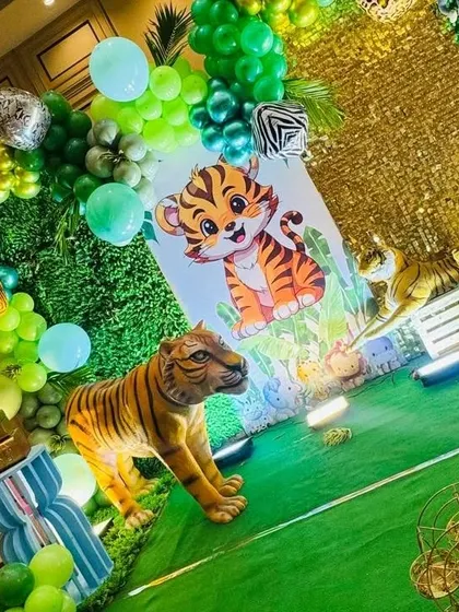 A close-up of the jungle stage, featuring a life-size tiger prop next to a cute cartoon tiger backdrop.