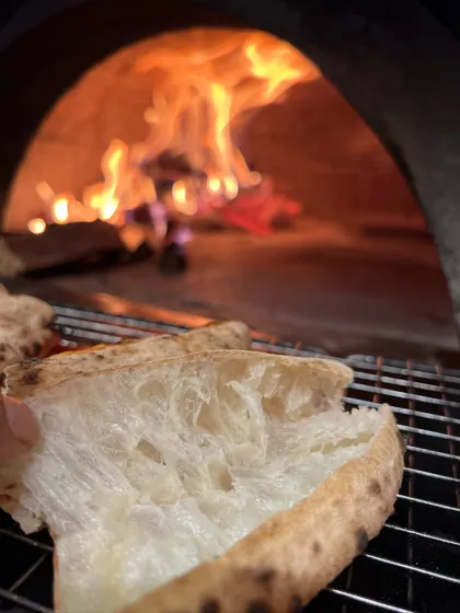 This is where the flavour is born. Our Neapolitan crust, with its soft, airy pockets, getting that perfect fire-kissed char from the wood oven. It's a difference you can taste.