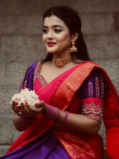 A client looking gorgeous in our purple and pink half saree. The puff sleeves with intricate embroidery are a detail we love to add for a touch of vintage charm.