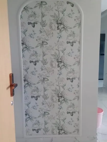 An arched niche filled with a beautiful floral wallpaper, turning an architectural detail into a piece of art.