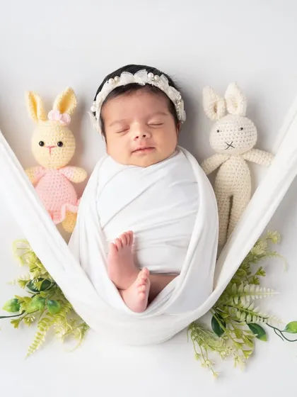 Two little bunny friends watch over this sleeping angel in a soft white hammock. It’s a simple, pure, and incredibly sweet setup for a newborn session.