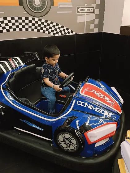 A toddler pretends to drive a toy car, an example of the imaginative play that helps children understand the world around them.