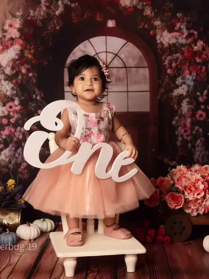 This little girl is celebrating her first birthday in our beautiful and rustic floral gate setup.