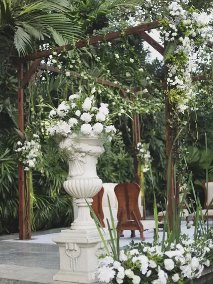 A detail shot of the rustic wooden ceremony arch, adorned with beautiful white floral arrangements.