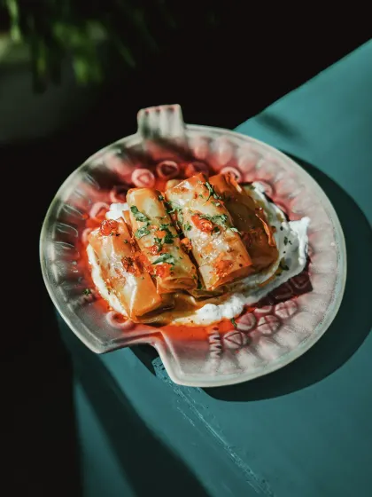 Inspired by a warm hug, this slow-braised lamb is enveloped in crisp filo, infused with aromatic spices, and paired with a zesty mint yogurt.