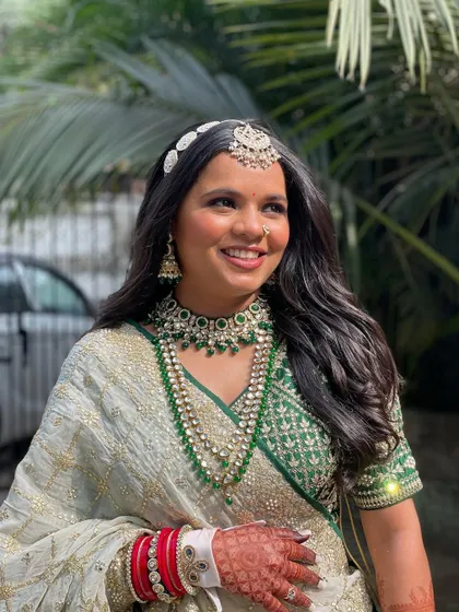 A simple and elegant open hairstyle with soft waves, paired with a traditional mathapatti. This look is perfect for the bride who wants a natural and radiant wedding day look.