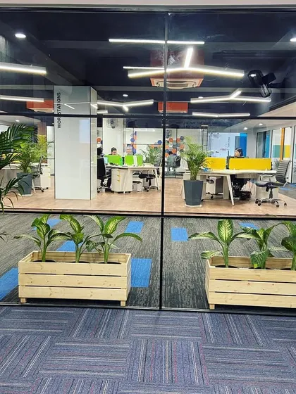 A view into the main workspace at Sahil Graphics in Faridabad. I used glass partitions to maintain an open and collaborative feel while providing some acoustic separation, with planters used as natural dividers.