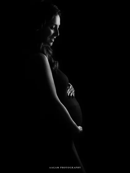 A minimalist portrait dedicated to all mothers. The soft light on her smiling face and baby bump is a beautiful tribute to motherhood.