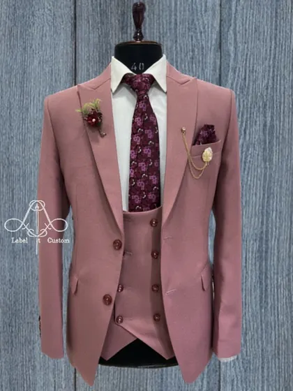 A dusty rose three-piece suit that challenges traditional formal wear. Paired with a floral tie, this is a confident and stylish choice for a daytime wedding or a special event where you want to stand out.