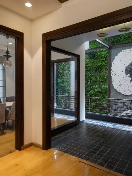 The dining area and a casual sit-out at the rear of Ashraya Residence are naturally lit by skylights. The adjacent vertical green wall enhances the connection to nature, blurring the boundary between inside and out.