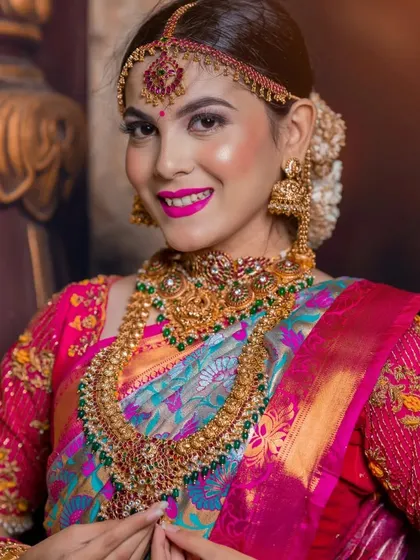 A classic beauty shot focusing on the model's smile and the stunning, colourful jewellery set.