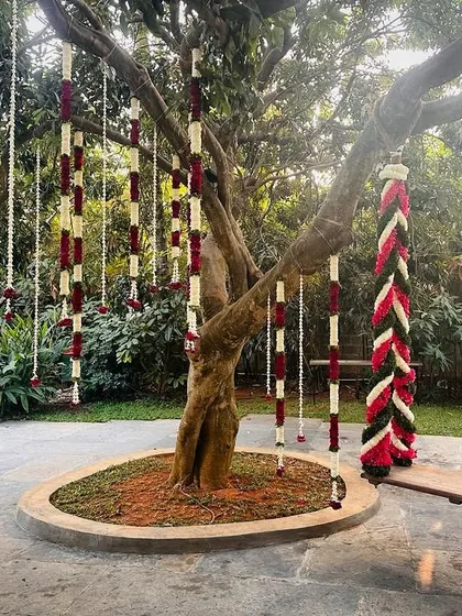 A beautiful floral oonjal (swing) decorated with red, white, and green flowers, combining tradition with elegance.