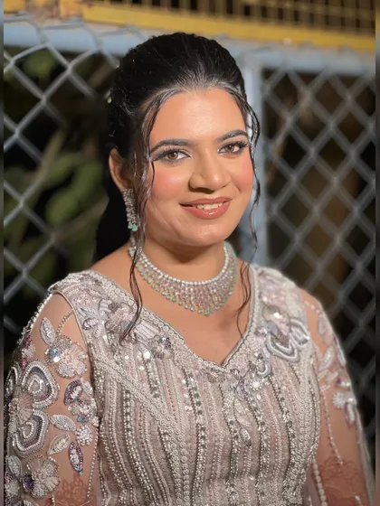 A close-up of the bride's wet-look hairstyle and shimmery makeup, a trendy choice for a sangeet night.