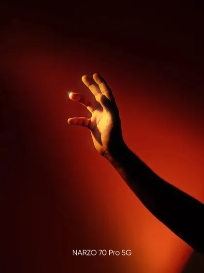 A creative shot of a hand illuminated by a warm, red light against a dark background, highlighting form and texture.