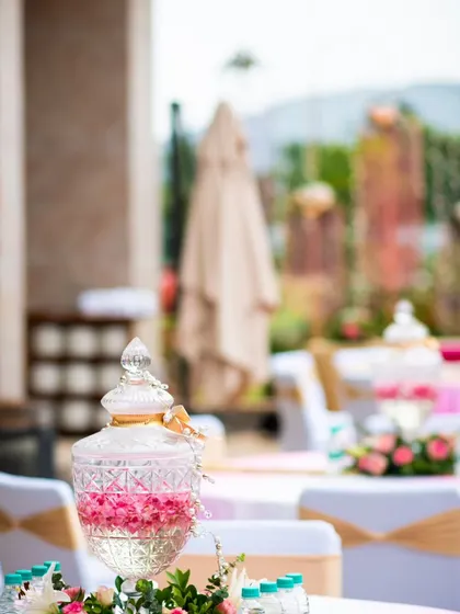 Another view of the elegant table settings at an outdoor event, with a focus on the floral centerpieces and the beautiful natural backdrop.