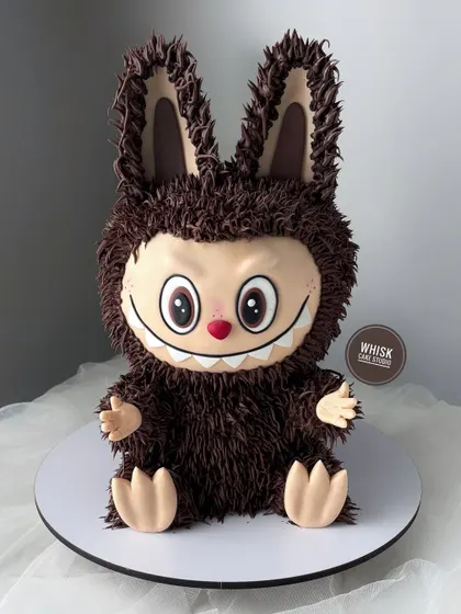 The Labubu cake trend is not stopping anytime soon. This brown version features the signature furry buttercream texture and wide grin.