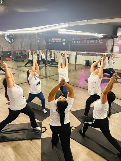 Our members holding a strong Virabhadrasana I or Warrior I pose. This asana builds stamina and concentration, and doing it together as a group amplifies the energy in the room.