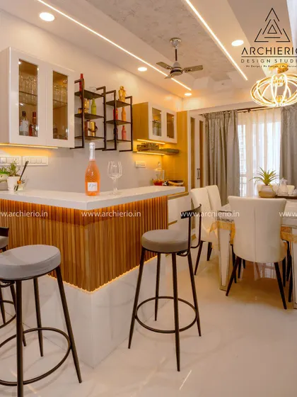 A stylish home bar and dining area at Candeur Signature apartments. The design uses fluted wood panels, modern bar stools, and elegant lighting to create a perfect space for entertaining.