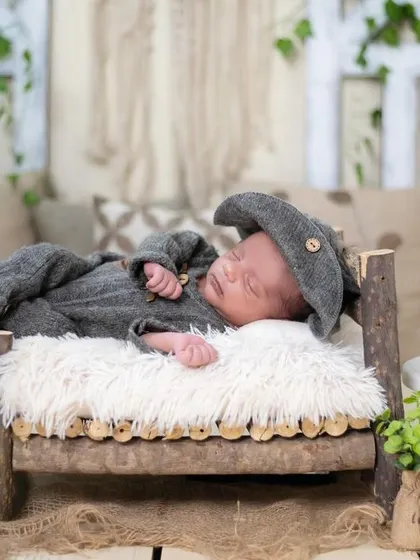This little one is resting peacefully in our rustic-themed setup. We use natural textures and props like this miniature wooden bed to create a warm, timeless feel.