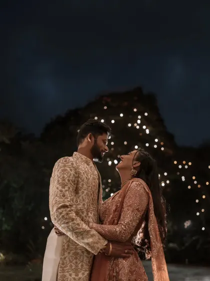 A candid laugh shared under a canopy of fairy lights. Night shoots allow us to play with light, creating a magical and intimate atmosphere that feels both celebratory and personal.