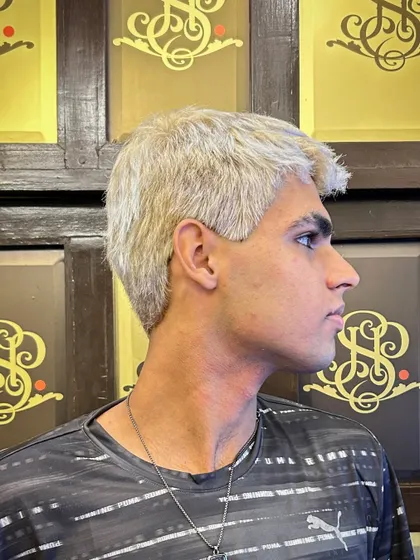 A side profile of the men's platinum blonde makeover. Achieving this clean, even tone requires skill and precision, especially on dark hair.