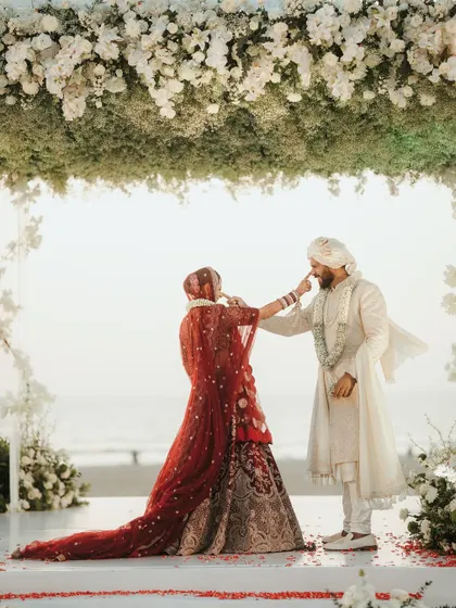 A playful and cute moment between the bride and groom during their beachside ceremony.