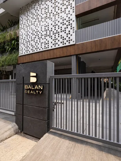 The gateway to the Skylight building sets the tone for the refined experience within. The clean lines of the gate, the bold signage on textured stone, and the glimpse of the perforated screen facade demonstrate a cohesive approach to contemporary urban architecture.