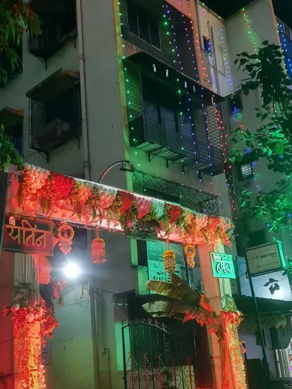 An illuminated entrance gate for a Haldi event at a house. The mix of floral decor and festive lighting creates a warm welcome.