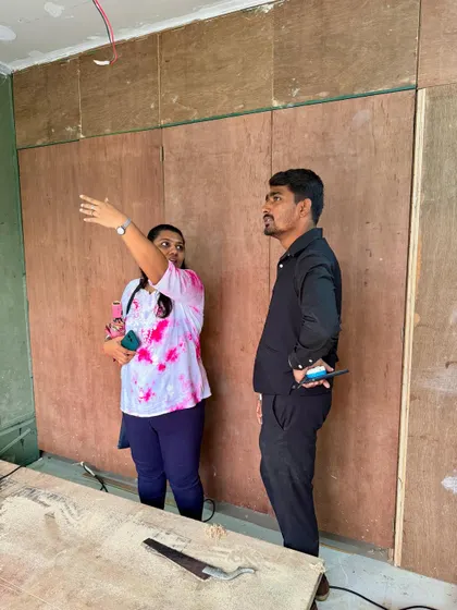 Discussing the wardrobe layout with a client in front of the base plywood structure. This is where we finalize heights and compartments.