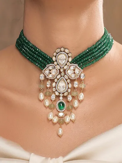A close-up of the emerald bead choker with its intricate polki and pearl pendant.