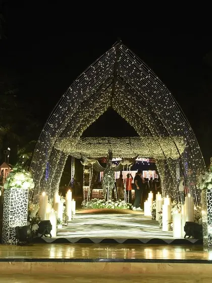 The first impression matters. We designed this stunning Sangeet entrance with a tunnel of lights, a personalized welcome mirror, and elegant white floral arrangements to set a tone of sophisticated glamour from the moment guests arrived.