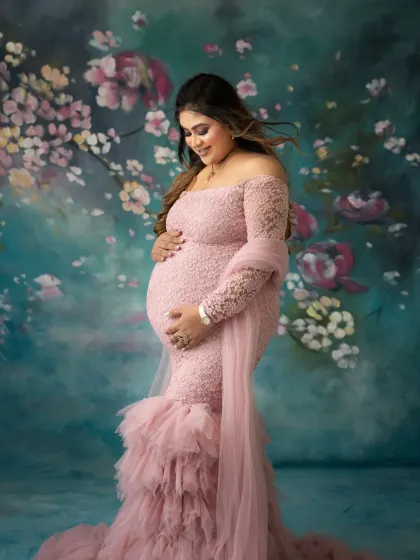 A solo portrait of the mama to be, looking down at her bump with so much love. The soft lace and flowing tulle of the gown add a romantic, dreamy quality to the image.