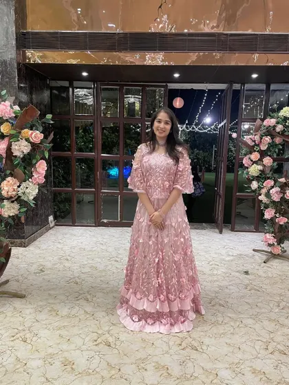 This embroidered pink Indo-western set, featuring a crop top, skirt, and cape with 3D floral details, is an iconic look for any young woman attending a wedding or reception.