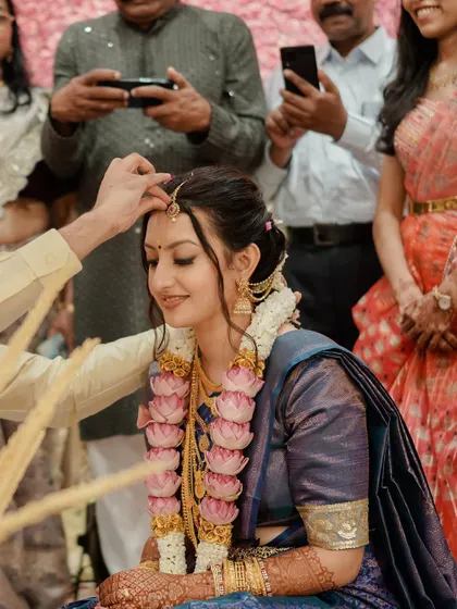 A beautiful moment from the ceremony. Her makeup is soft and serene, perfect for these intimate rituals.