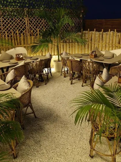 An overhead view of the bamboo-enclosed seating section at Sesh. The design uses natural partitions and greenery to create distinct zones that feel both connected and private.