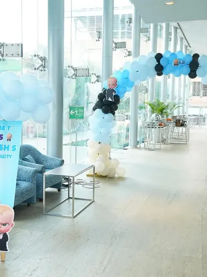 A Boss Baby-themed entrance with a blue, black, and white balloon arch and a personalized welcome sign.