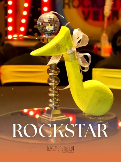 A centerpiece from a Rockstar-themed party, featuring a bright yellow musical note. The text overlay emphasizes the theme, showing how I brand each event.