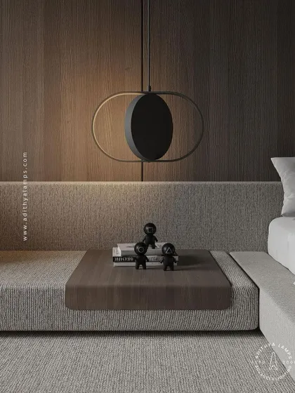 A minimalist pendant featuring a central black disc within a gold oval frame, resembling a solar eclipse. This fixture is a perfect example of less is more, providing soft, indirect light for a serene bedroom or reading nook.