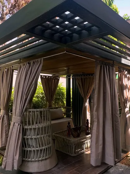 A wider view of the elegant gazebo, showing its sturdy structure and how it sits within the lush landscape, offering a perfect vantage point to enjoy the garden.