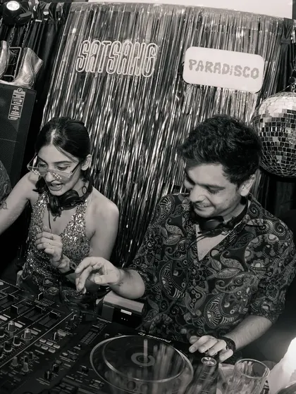 A black and white shot of me and a fellow DJ sharing a laugh behind the decks. Collaboration is key to my events, and I love sharing the console with artists I admire.