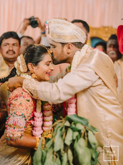 An emotional and candid moment during the wedding ceremony. The groom's affectionate kiss on his bride's forehead is a testament to their love story.
