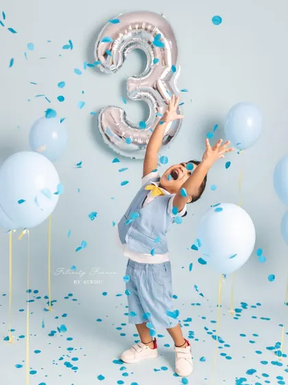 Pure joy and excitement! This three-year-old is loving the confetti shower during his birthday photoshoot.