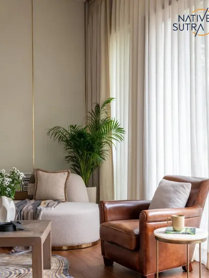 This cozy corner is designed to feel like a warm hug. The caramel-toned leather armchair, lush indoor palm, and sheer curtains create a light-filled, serene spot to pause and unwind.